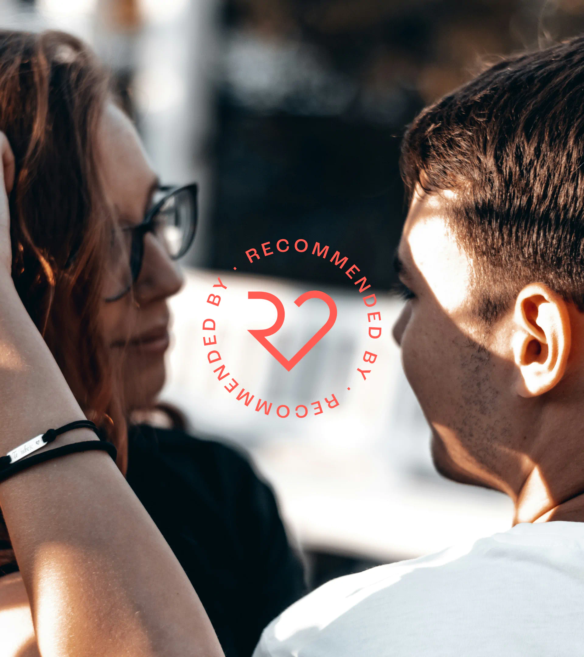 Couple smiling outdoors with Recommendating’s circular brand stamp overlay, highlighting visual identity and warm brand tone.