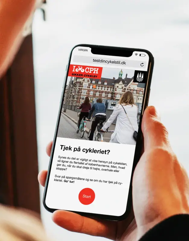 Københavns Kommune cycling campaign shown on a smartphone, presenting a mobile-first public information experience with clear messaging and an engaging civic design approach.