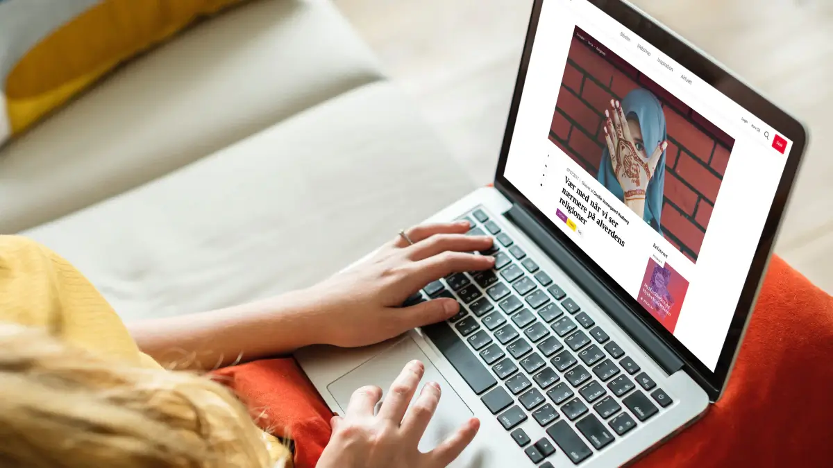Laptop mockup showing the Bibelselskabet website, featuring an editorial article layout with strong imagery, clear navigation, and a modern digital publishing interface.