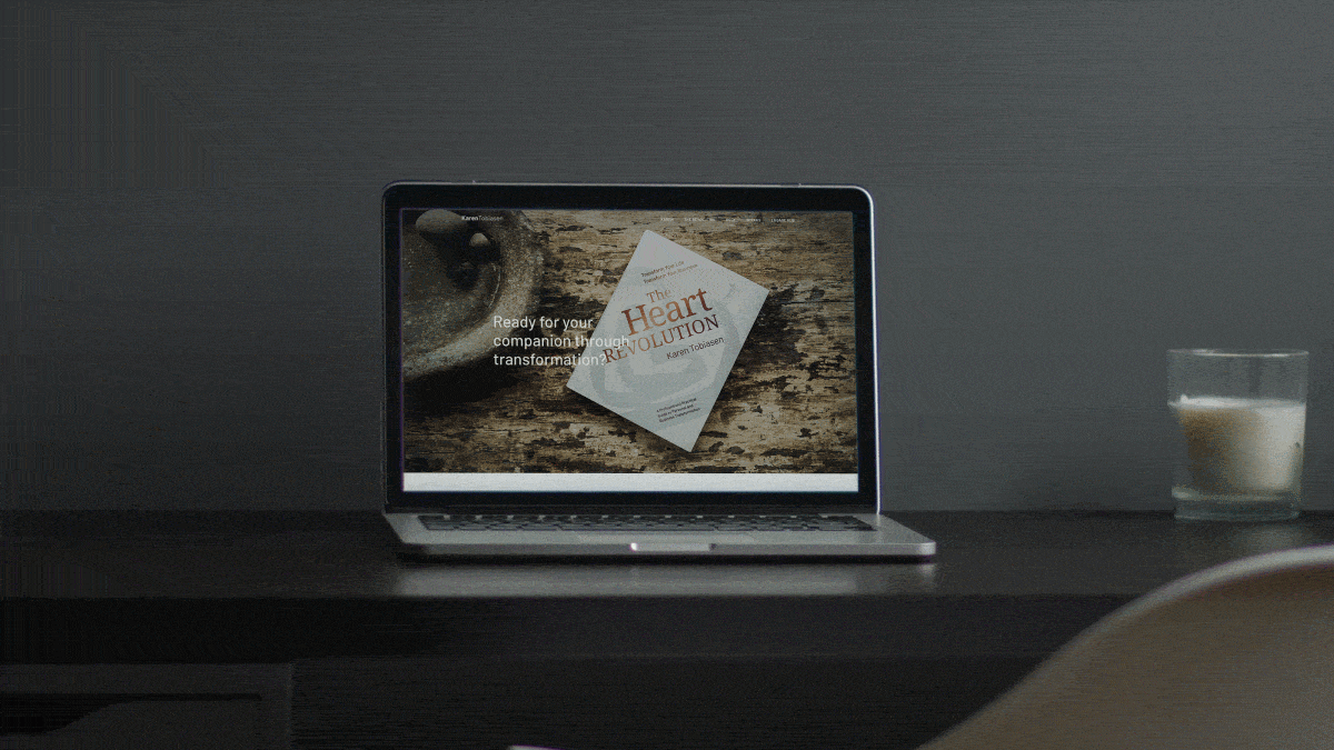 Animated laptop mockup showing Karen Tobiasen’s website, featuring a calm editorial homepage centered around the book The Heart Revolution and a personal transformation-focused brand presence.