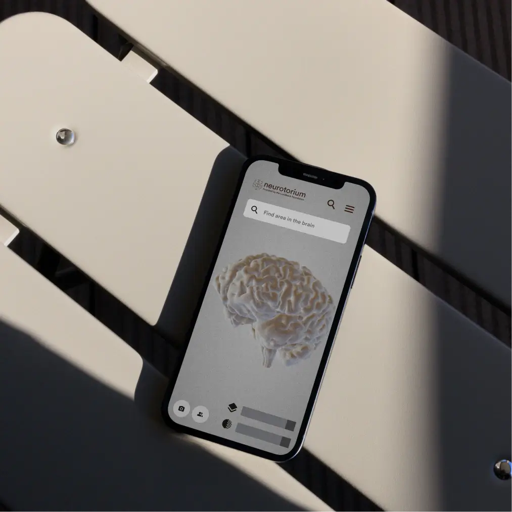 Neurotorium brain atlas mobile app displayed on smartphone with 3D brain model and area search functionality
