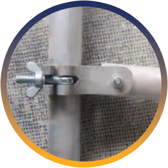 Metal clamp with wing nut securing two cylindrical metal pipes against a mesh background.