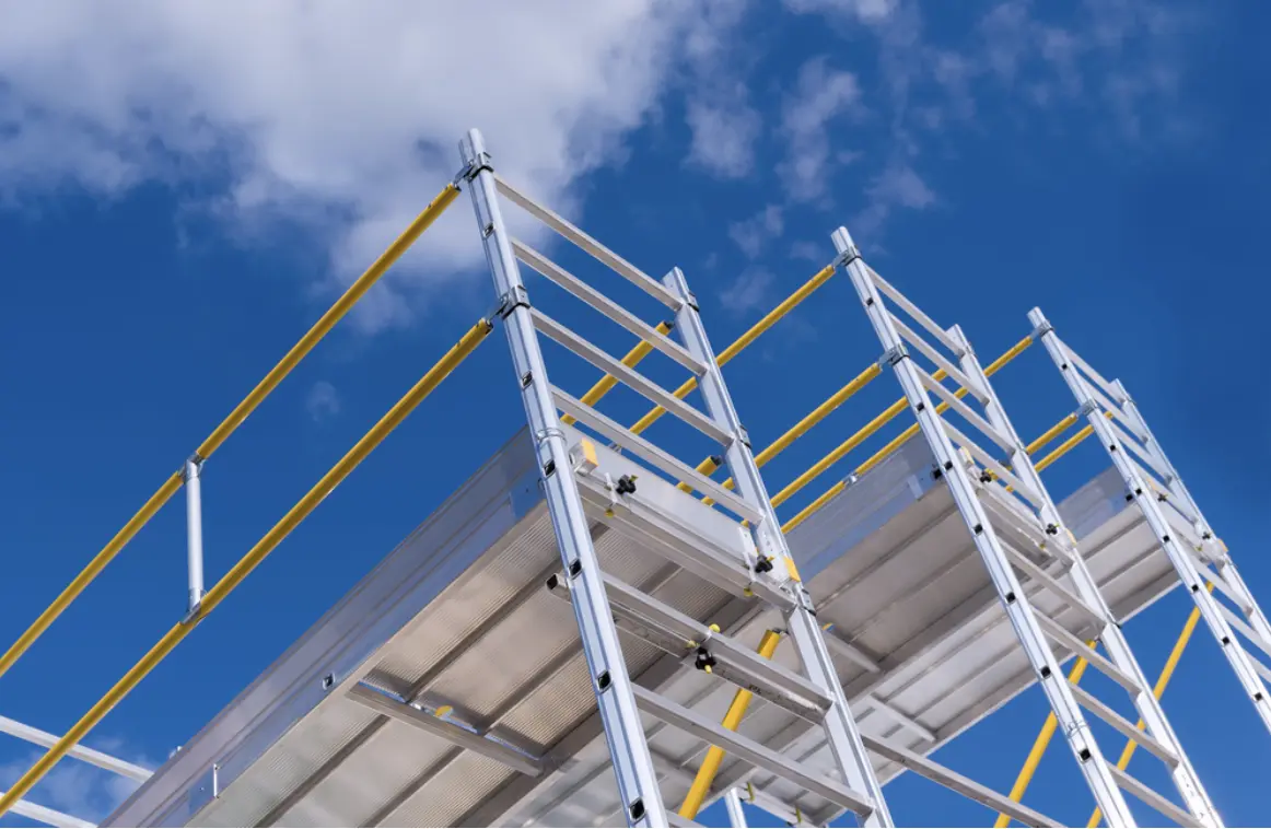 Aluminium scaffolding tower with platform and diagonal braces photographed from below against a blue sky