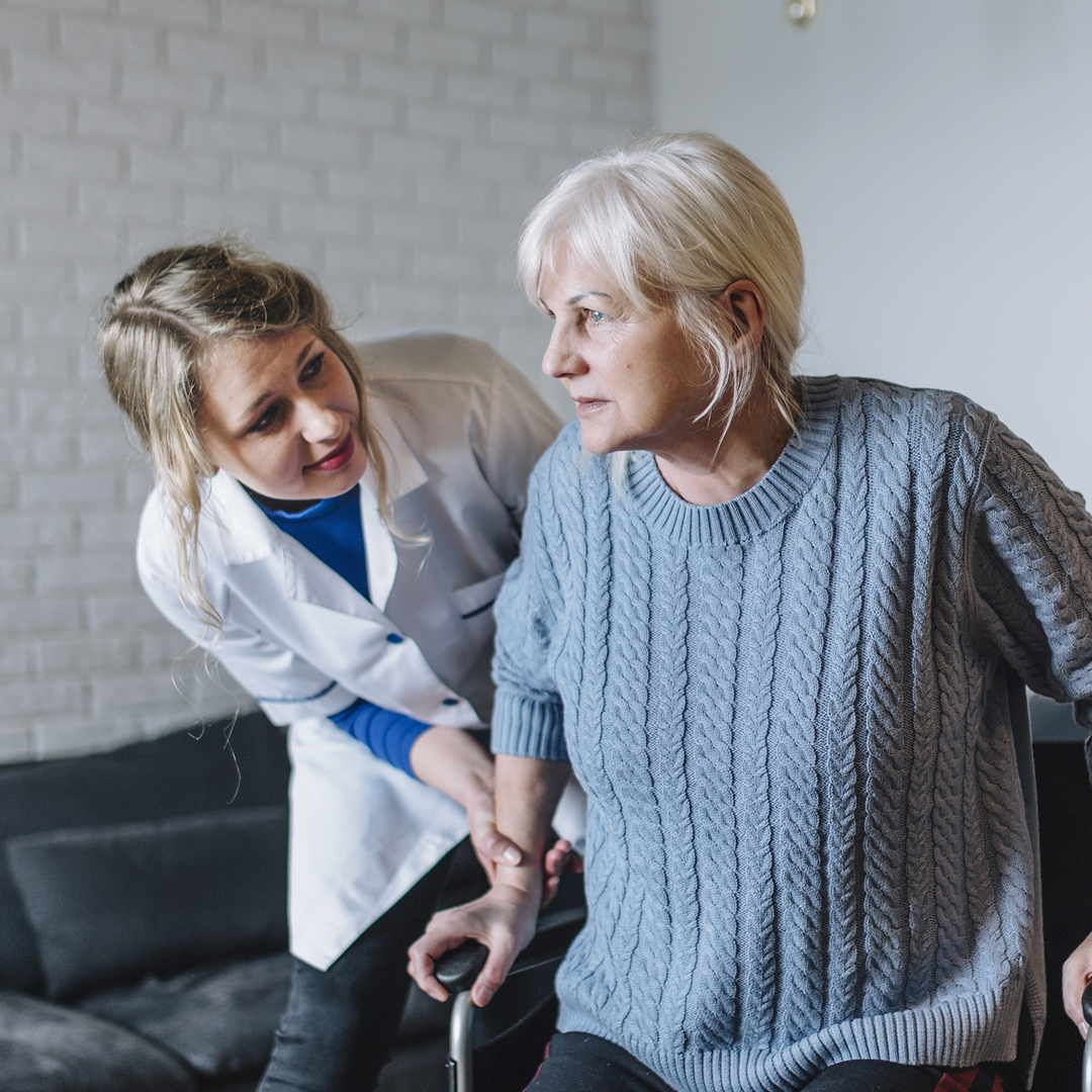  Caregiver assisting elderly woman in her living room