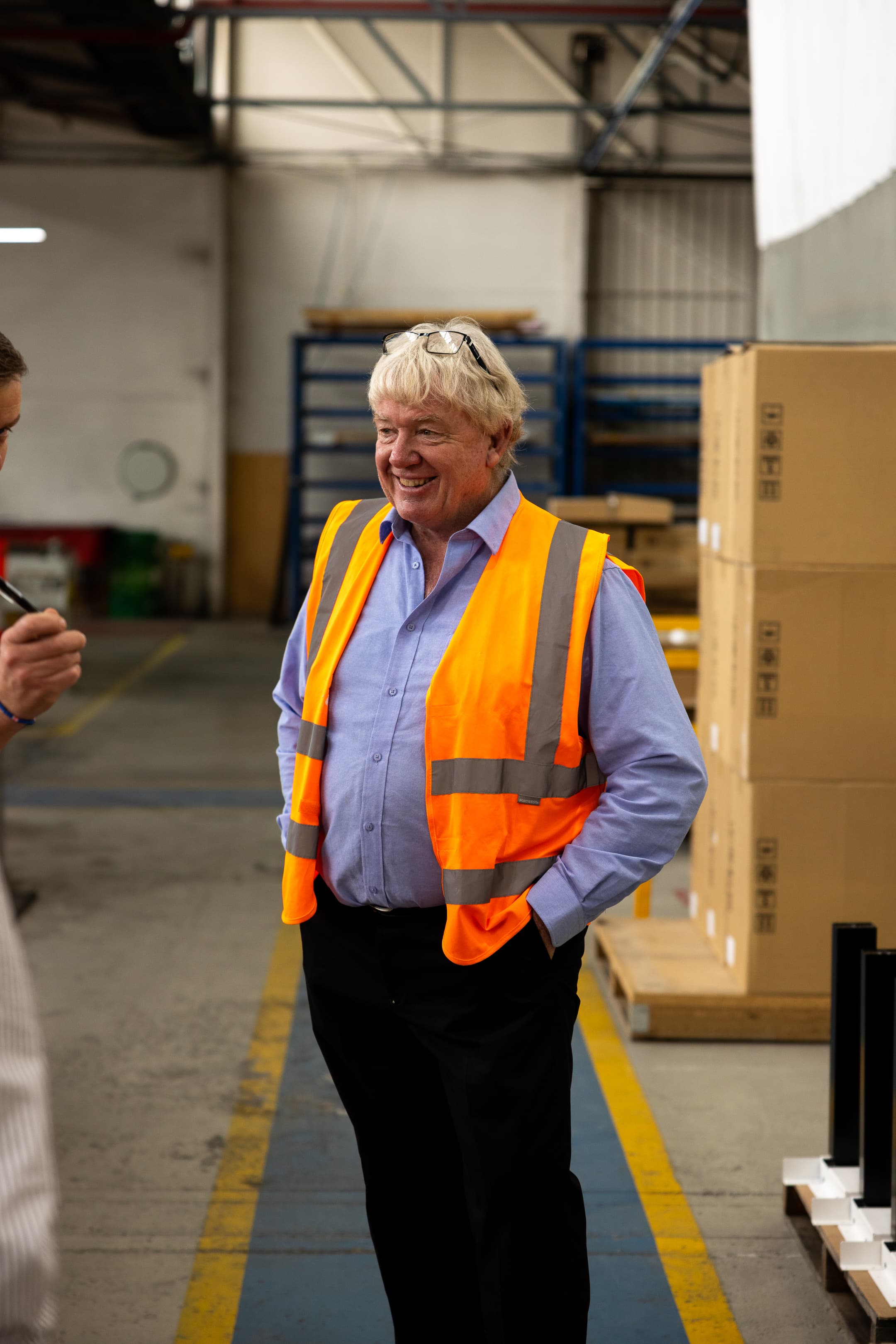 Brenton Matters wearing safety vest inside Behn® manufacturing facility, speaking with team during production visit