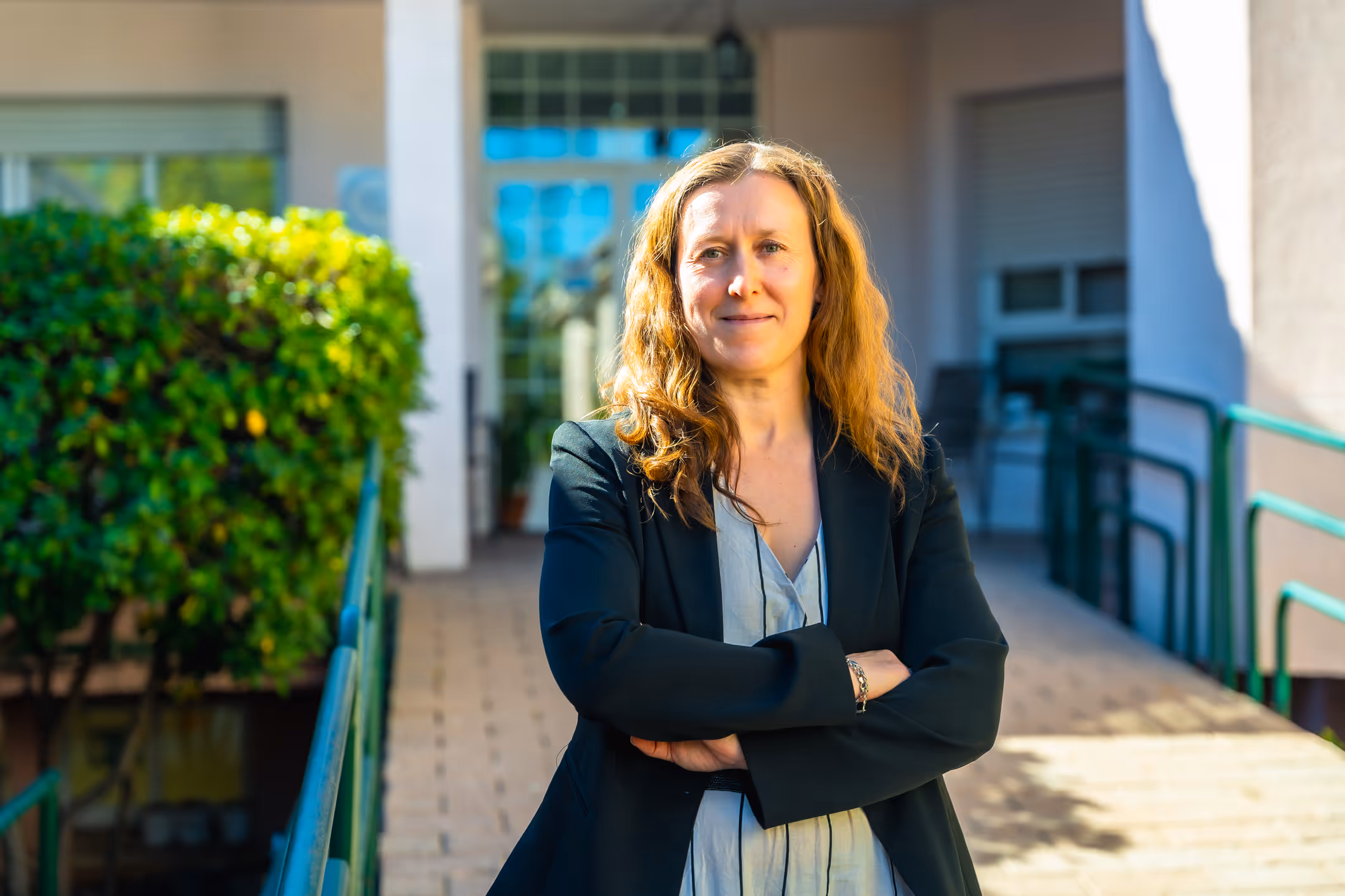 Confident female healthcare professional standing outside aged care or medical facility
