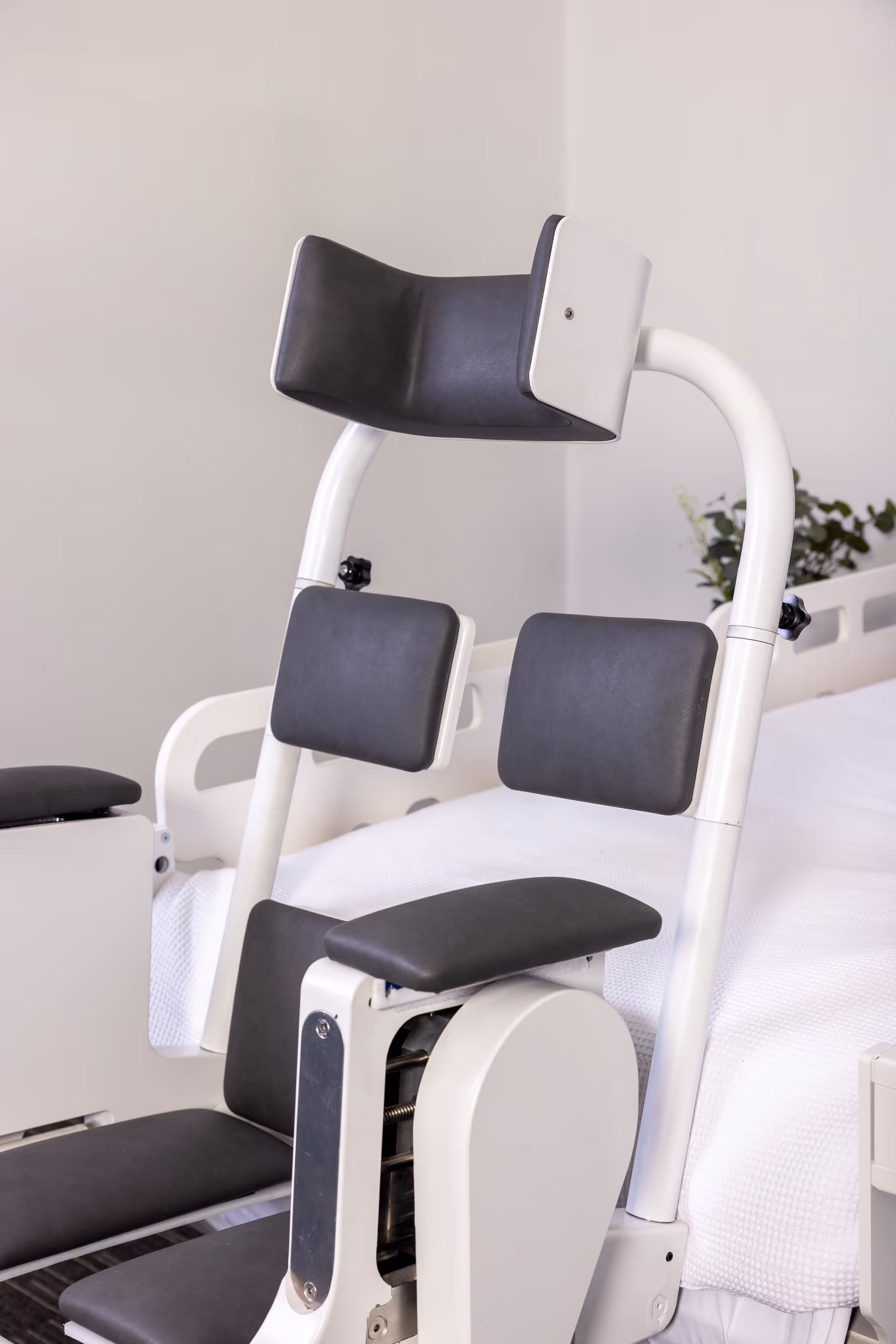 Close-up of Behn® assistive transfer chair showing ergonomic backrests and head support in docked position