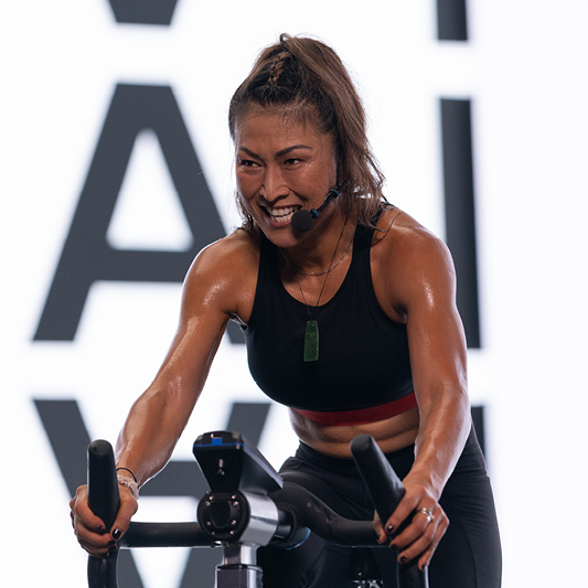 Tommi Wong on a stationary bike teaching a class 