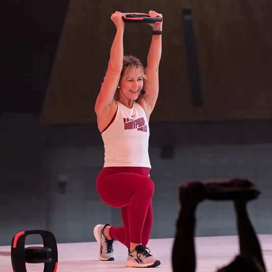 Les Mills Creative Director Kylie Gates lifing a Smartbar Plate