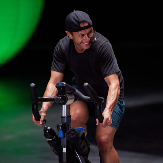 Person on a stationary bike, smiling while working out