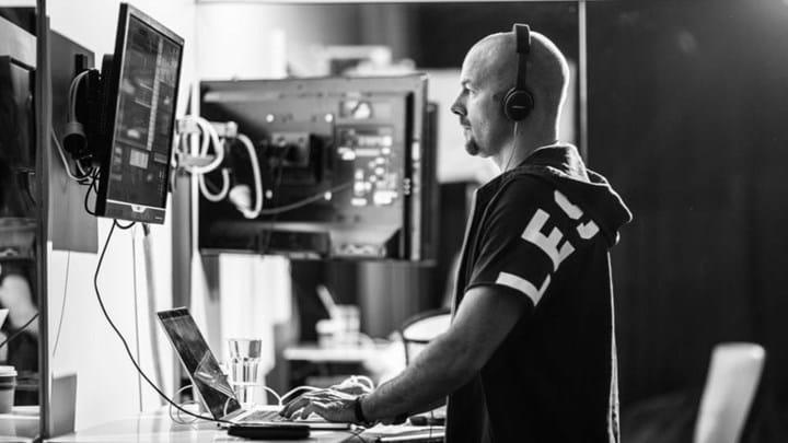 A person stands at a music mix desk