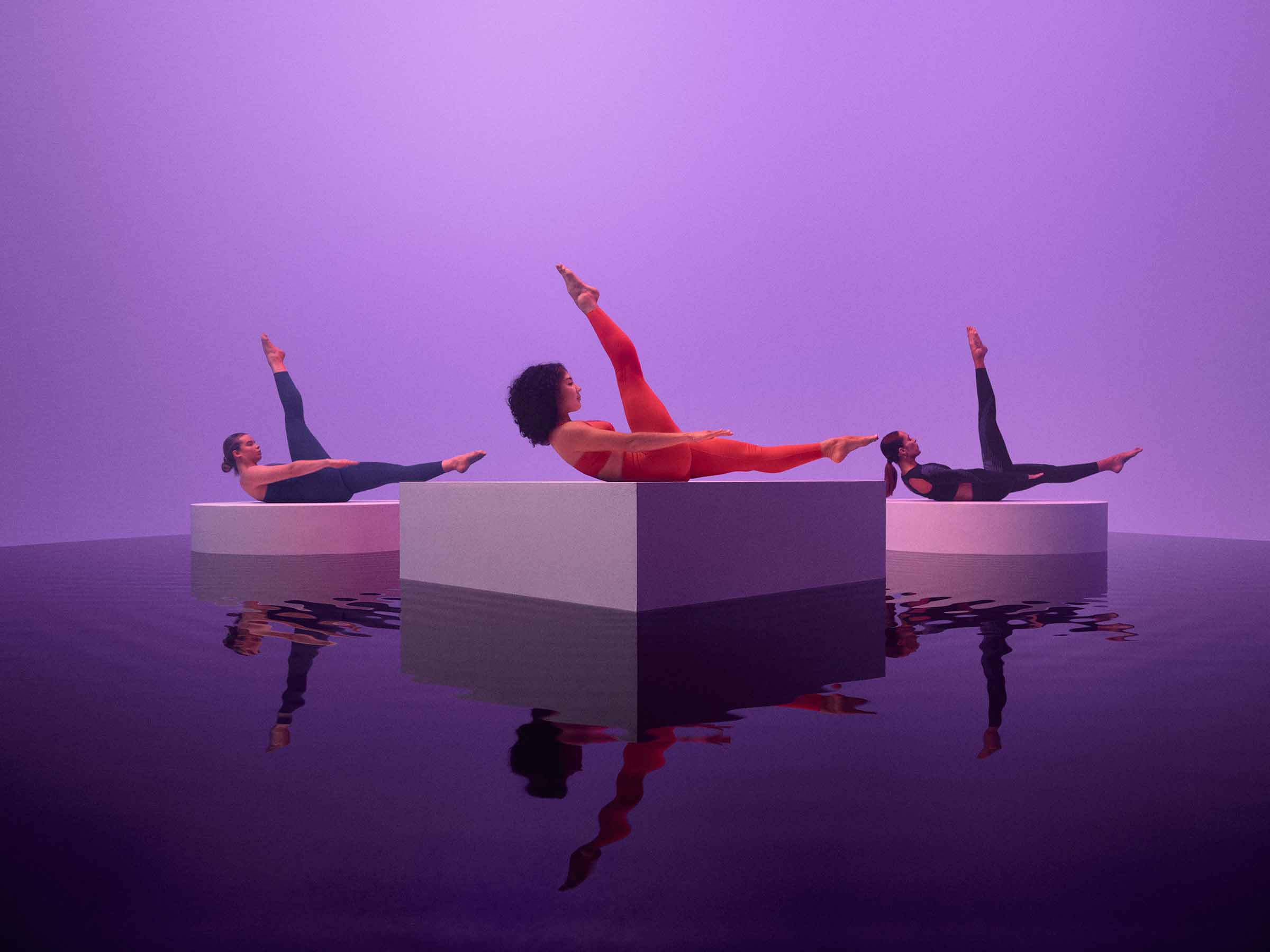 Three people performing pilates