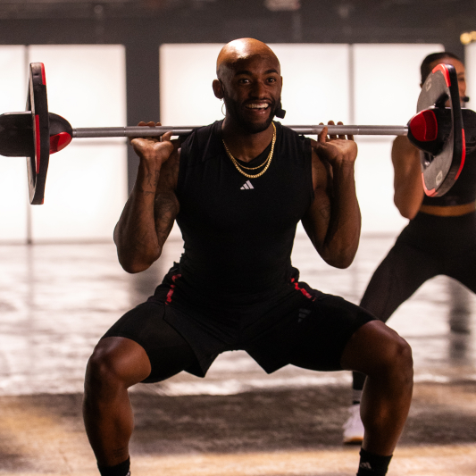 Instructor lifting a Les Mills Smartbar