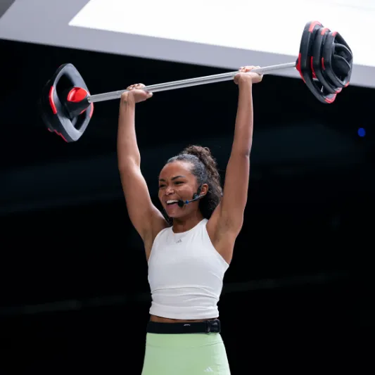 Instructor raising a Les Mills Smartbar above her head