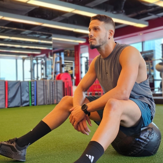 Instructor sitting on a medicine ball in a gym