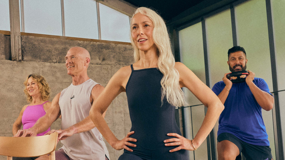 A group of people doing a low impact workout, one person has a weight plate