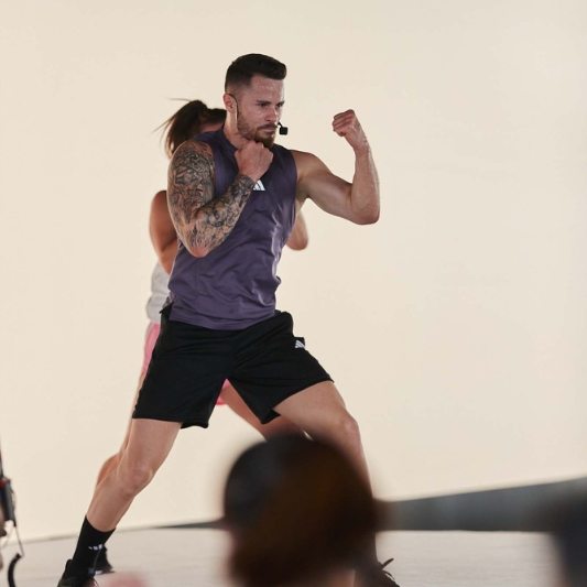 Image of Maxime Vigeant demonstrating a BodyCombat move to an audience