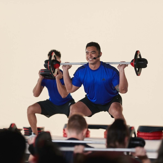 Image of Reagan Kang demonstrating a BodyPump move using a Les Mills SmartBar