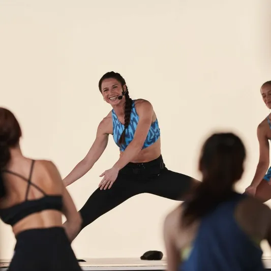 Image of Charlotte Ranque, wearing a blue singlet and black tights, demonstrating a workout.