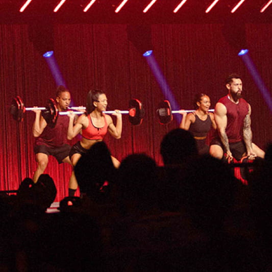 A group of Instructors demonstrating a BodyPump workout