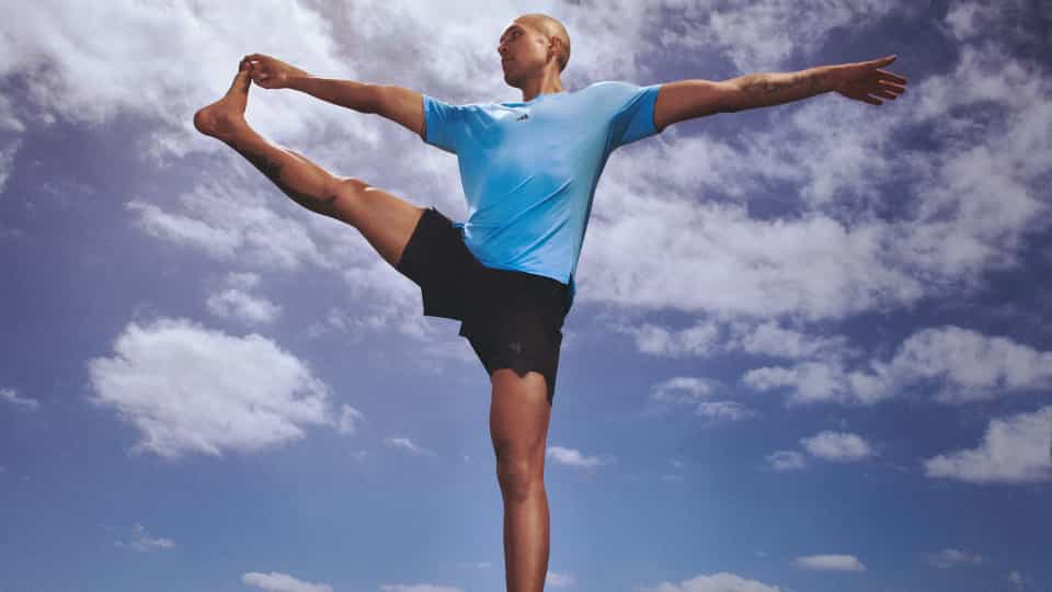 Instructor standing on one leg stretching