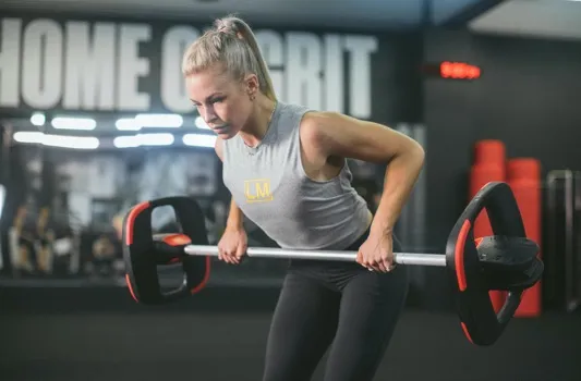 Instructor demonstrating a workout move using a Les Mills Smartbar