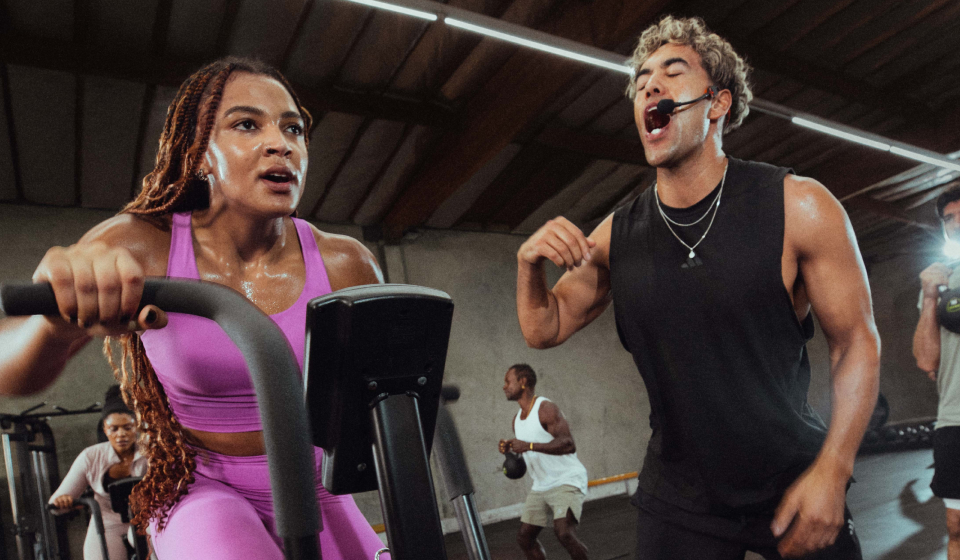 An instructor encouraging a participant on a stationary bike