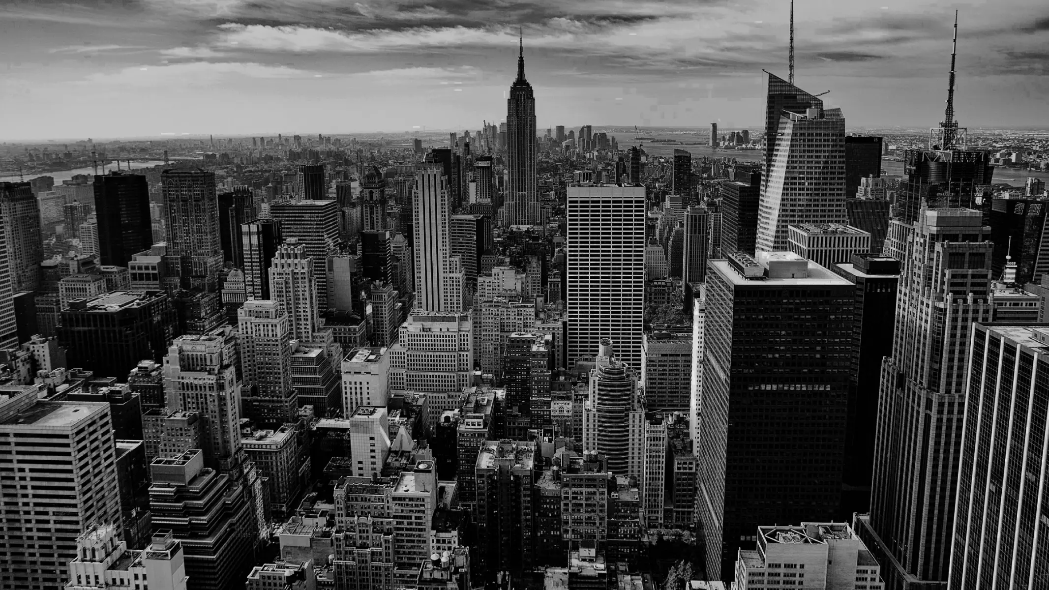 aerial view of Manhattan, New York City, featuring a dense cluster of skyscrapers including the iconic Empire State Building