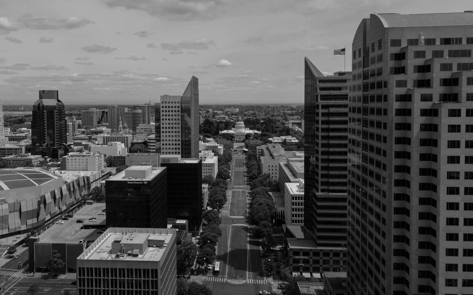 Aerial view of downtown Sacramento, California, featuring a mix of high-rise buildings and tree-lined streets