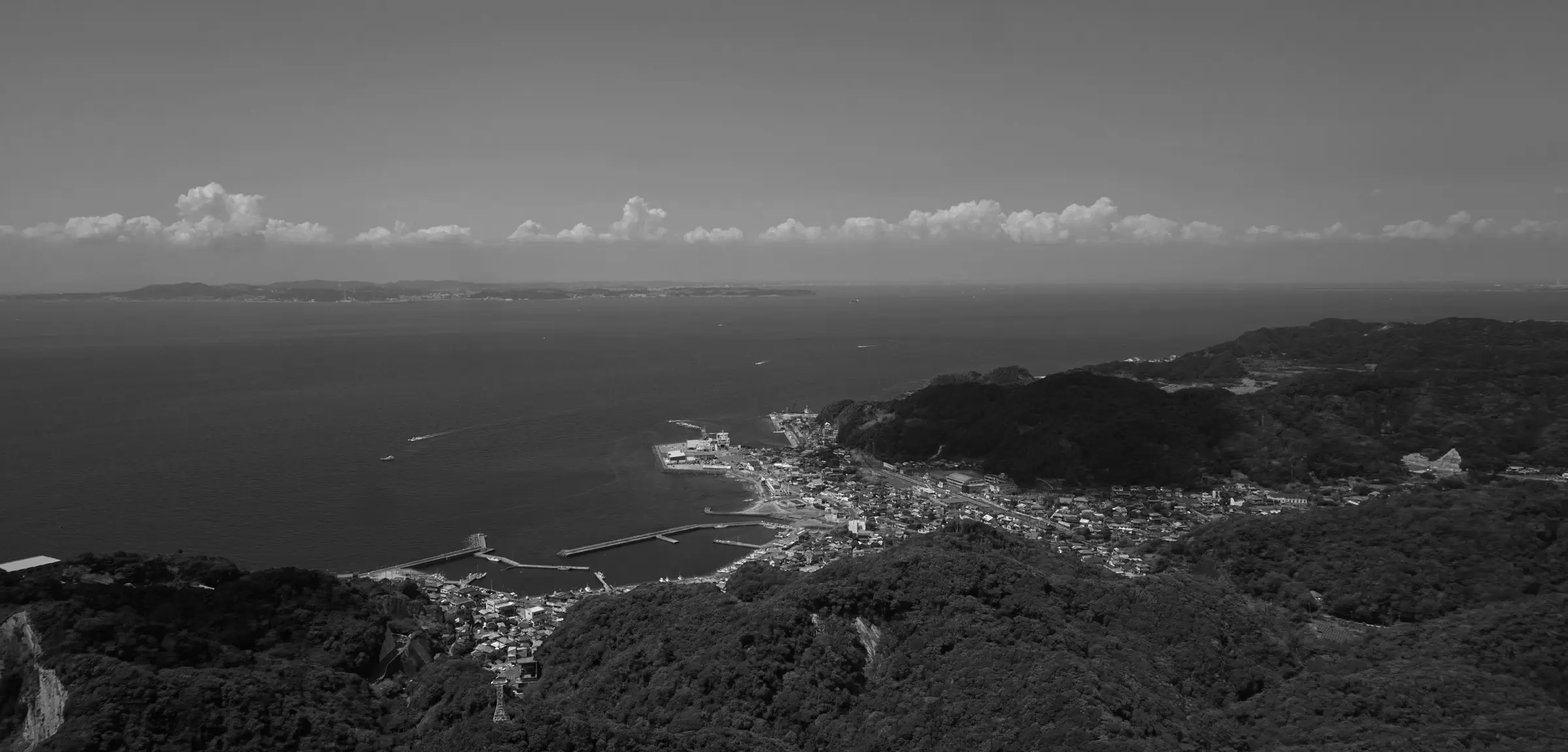 Aerial view of Chiba showing a coastal town, green hills, and harbor docks
