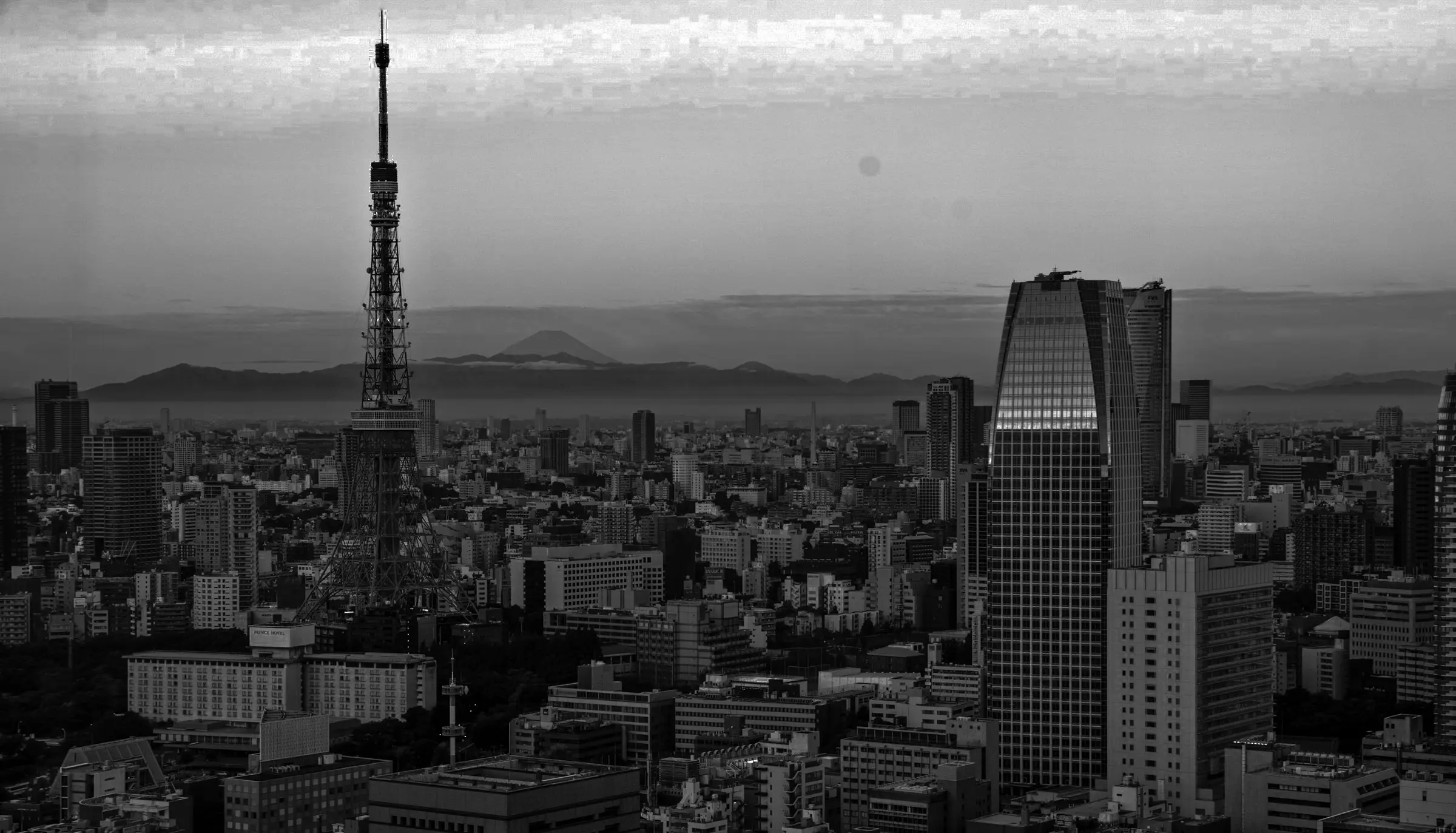 Panoramic view of Tokyo featuring Tokyo Tower, modern skyscrapers, and Mount Fuji