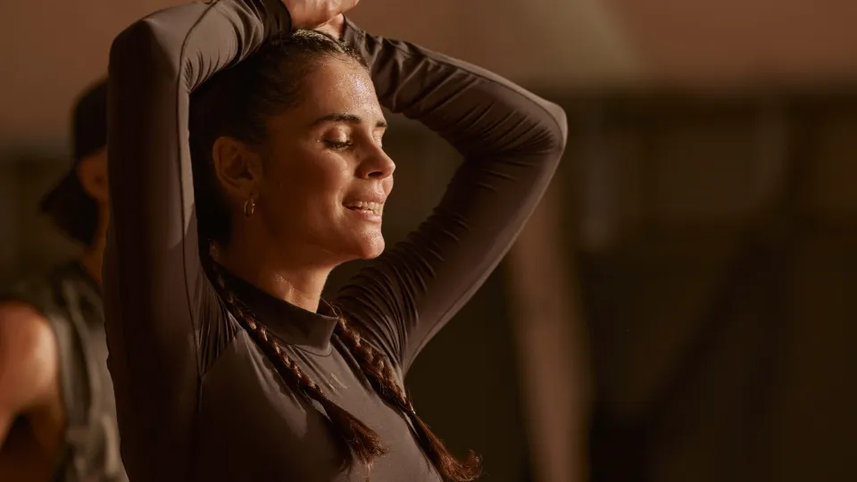 a person with arms raised and hands resting on the head.