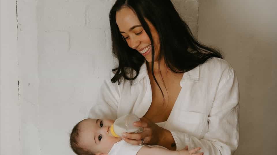 Dee Rowell bottle feeding her infant