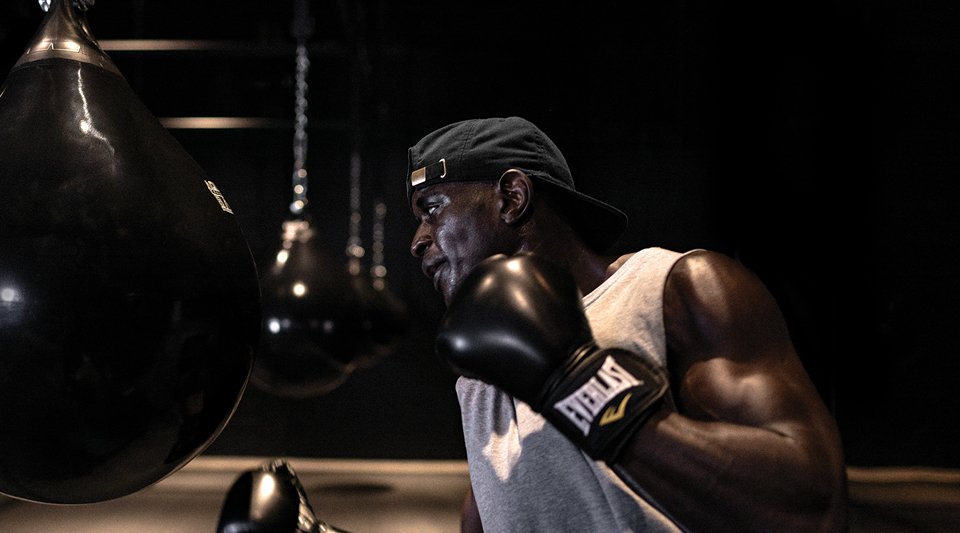 Person wearing boxing gloves training with teardrop punching bags