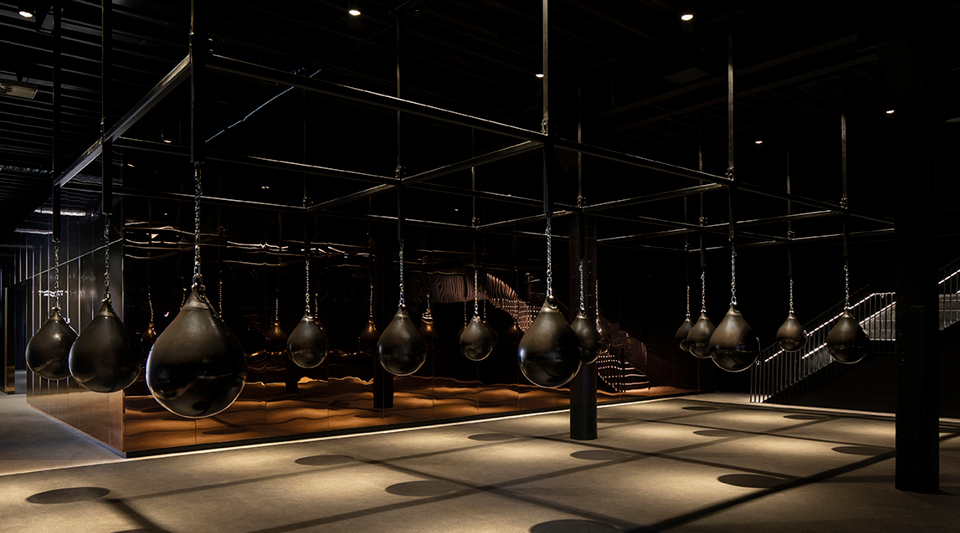 Dark gym with rows of teardrop-shaped punching bags hanging