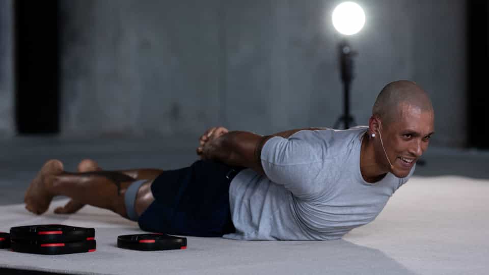 Person lying face down on mat with arms clasped behind back