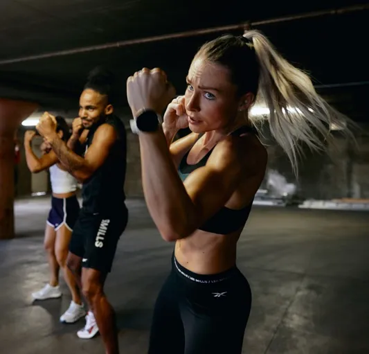 Group fitness class practicing boxing moves in an indoor space