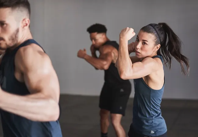 People in athletic gear performing boxing moves