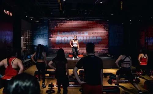 Instructor leading a Bodypump class on stage