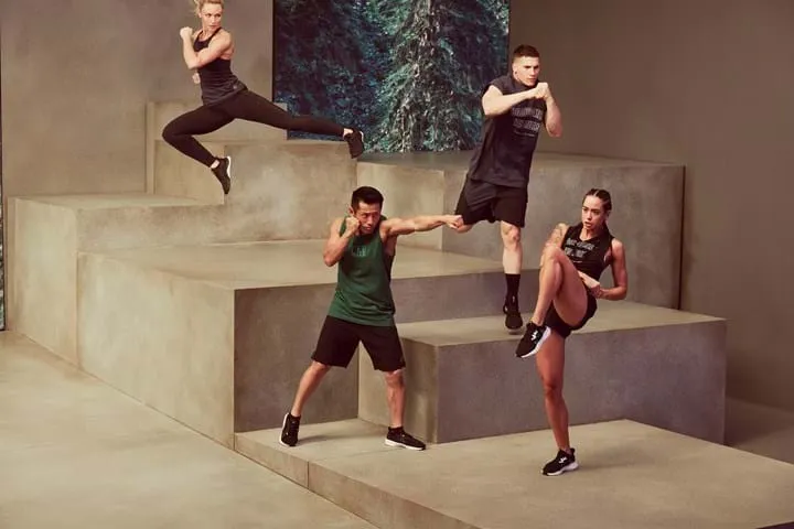 Four people performing dynamic moves on tiered platforms