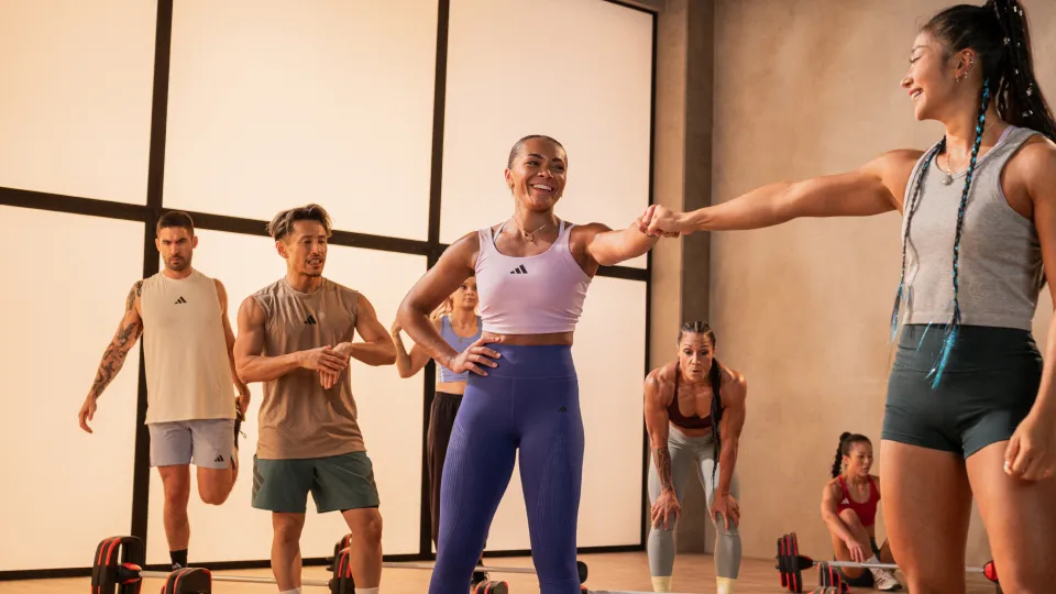 Two women celebrating in a group strength workout.