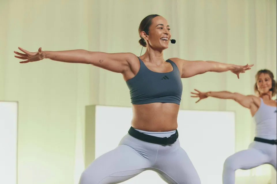 LES MILLS Instructor smiles as she leads a yoga class