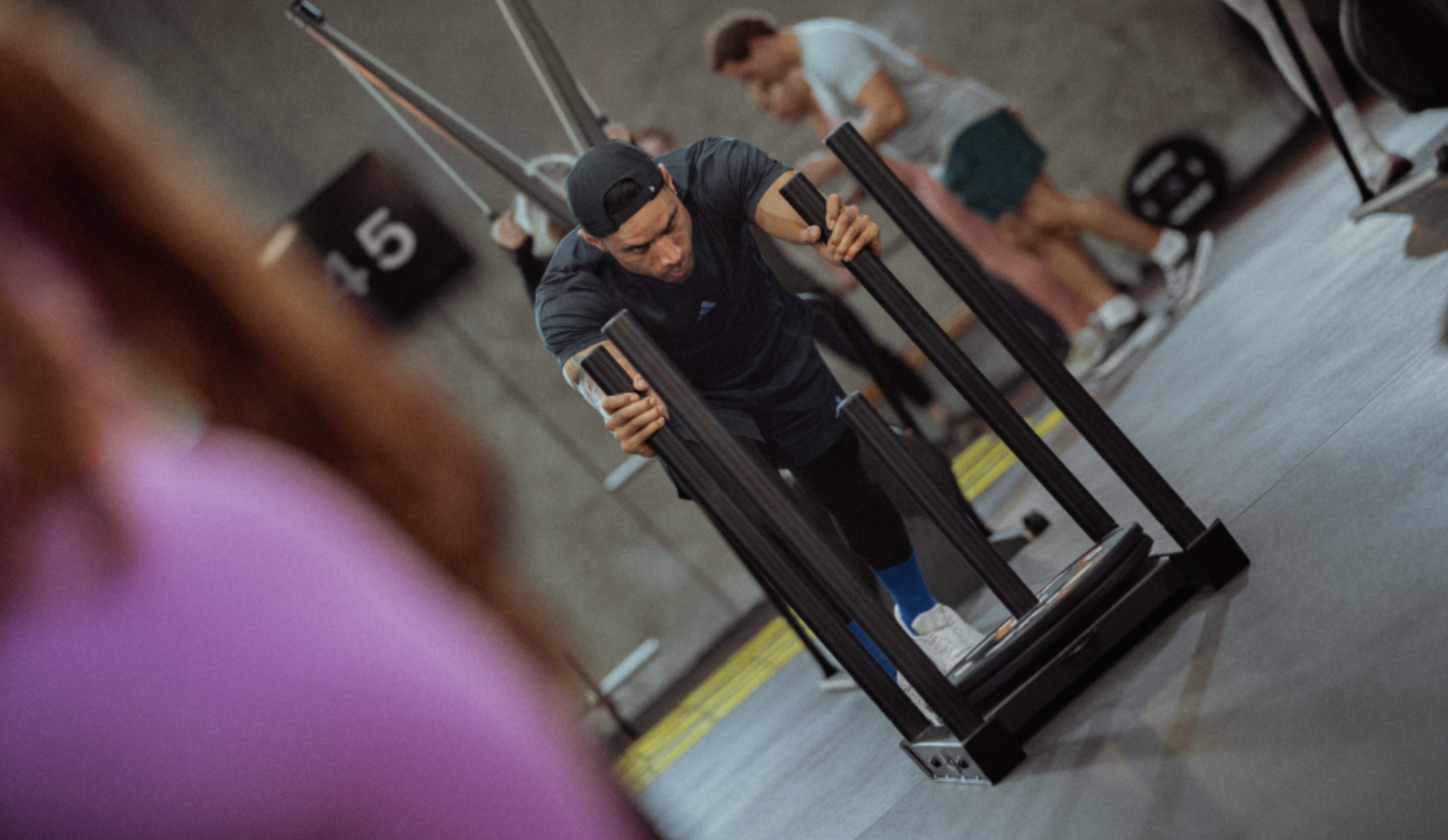 group training participant pushes a sled in Les Mills Ceremony