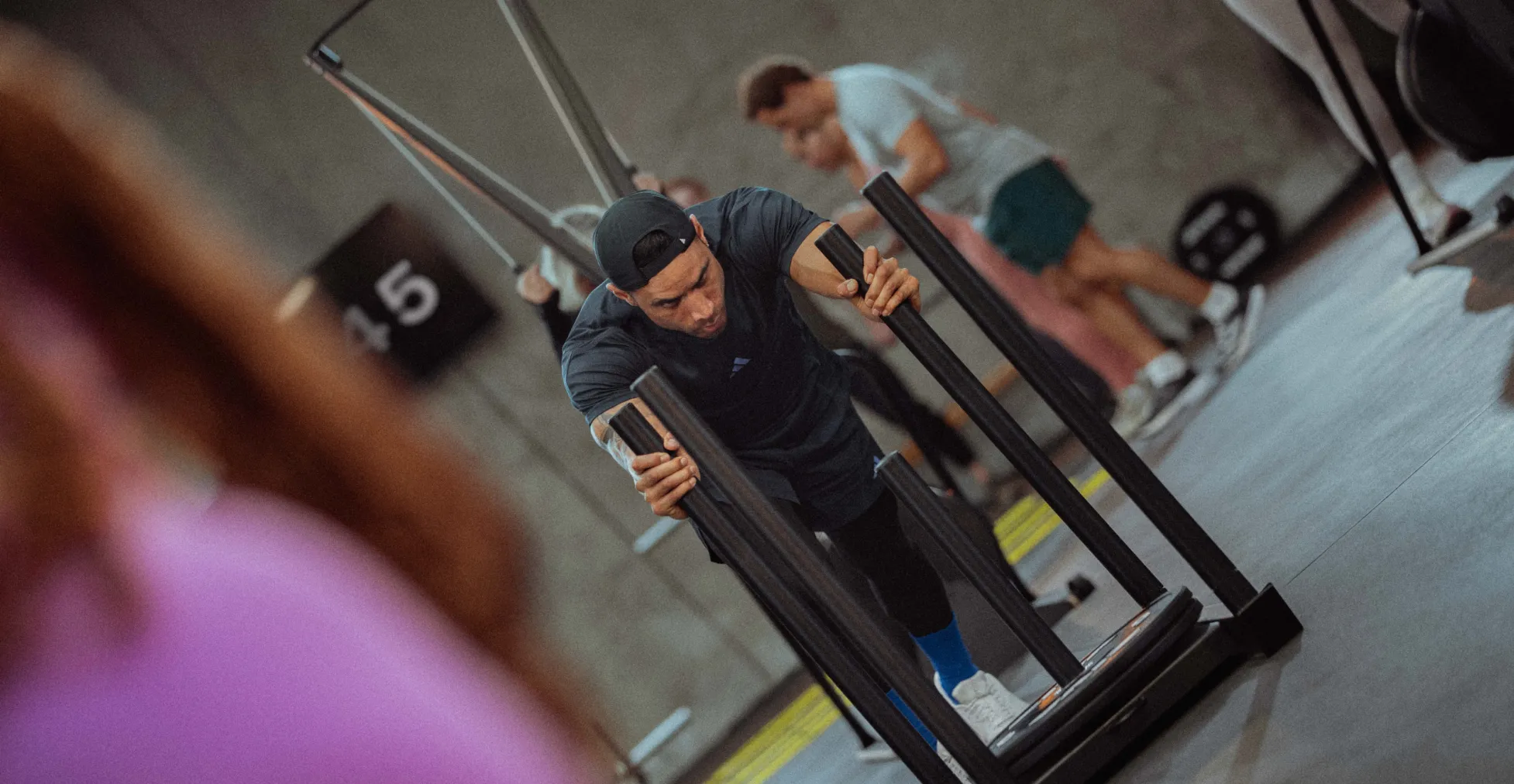 A man pushing a sled in a circuit workout