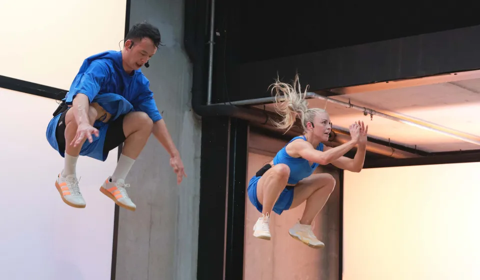 Erin Maw and a male in blue doing tuck jumps