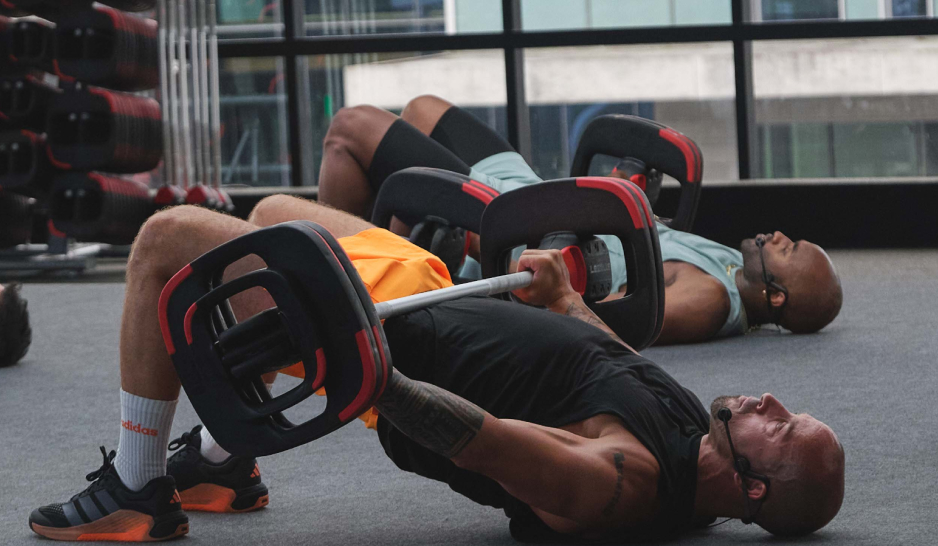 Two men doing hip thrusts with a barbell