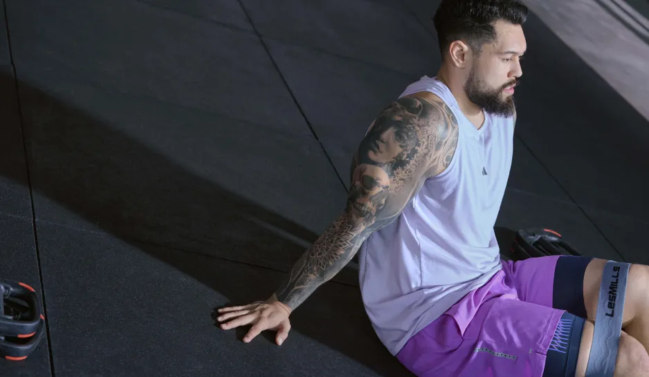 A man in purple, sitting alone at the gym