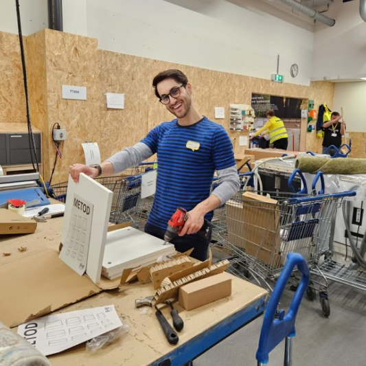 A man with a hand drill in a workshop