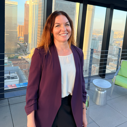 A woman in a purple blazer standing on a balcony