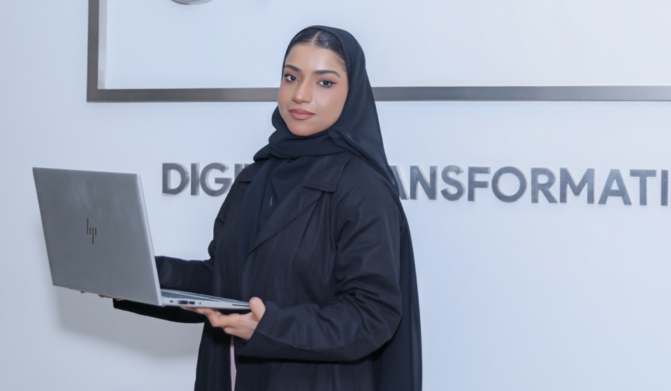 A woman in a black hijab with a laptop